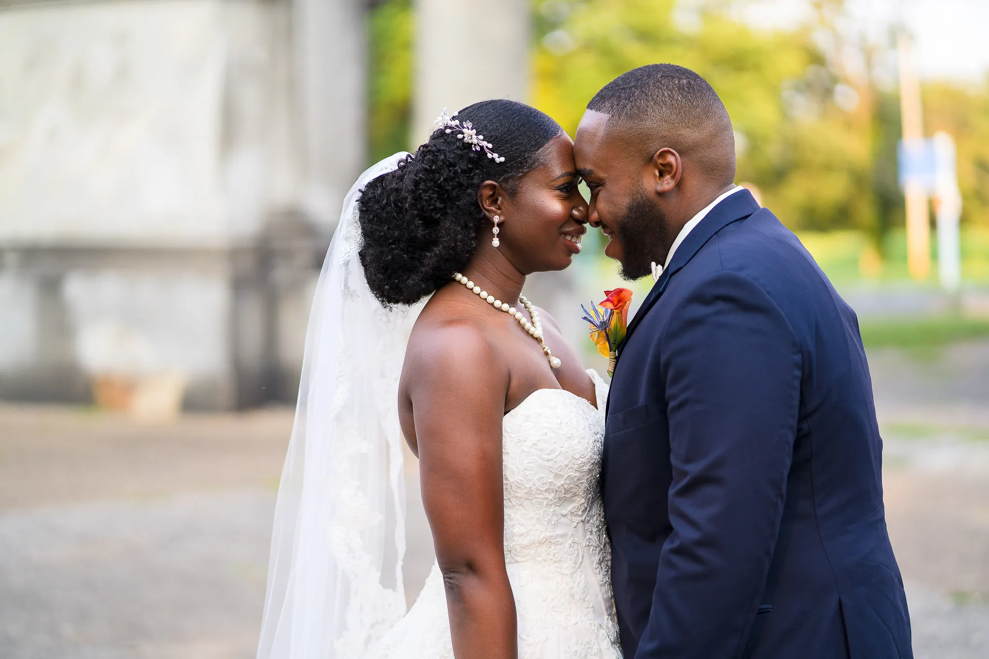 Bride and groom touching foreheads outside after their ceremony