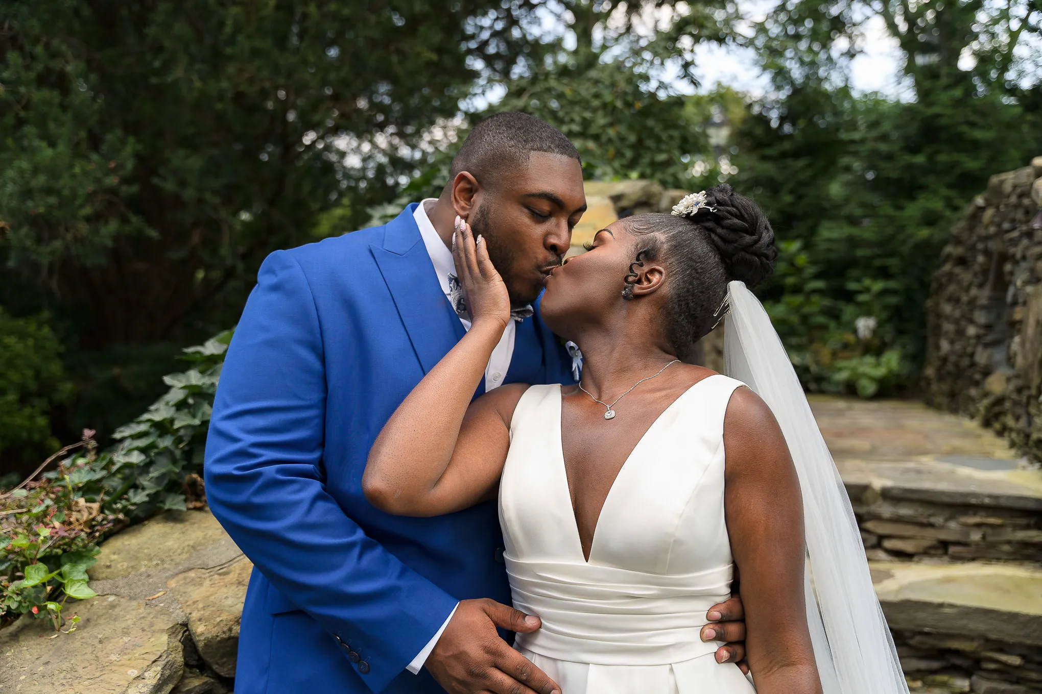 Bride and groom kissing in a stone garden