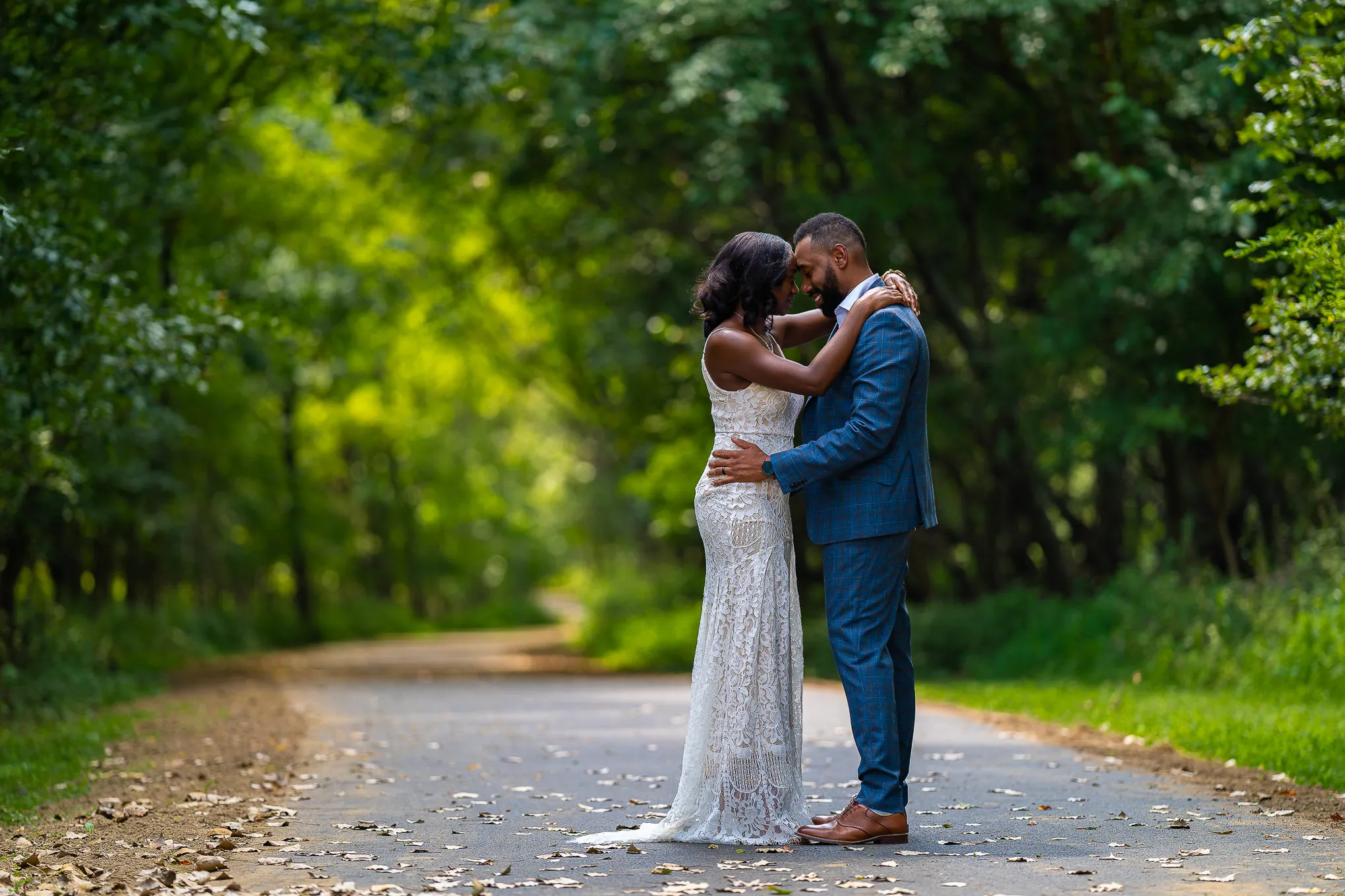 Couple embracing on a tree-lined path